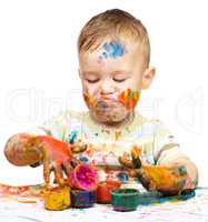 Little boy is playing with paints