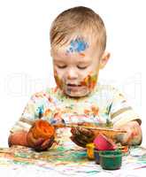 Little boy is playing with paints