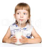 Cute little girl drinks milk using drinking straw