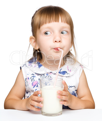 Cute little girl drinks milk using drinking straw