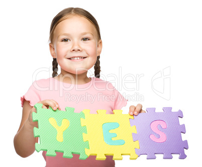 Cute little girl is holding Yes slogan