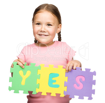 Cute little girl is holding Yes slogan