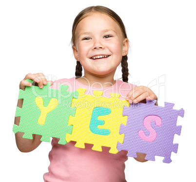 Cute little girl is holding Yes slogan