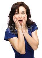 Woman is holding her face in astonishment