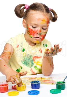 Portrait of a cute girl playing with paints