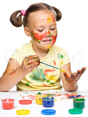 Portrait of a cute girl playing with paints