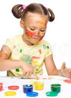 Portrait of a cute girl playing with paints