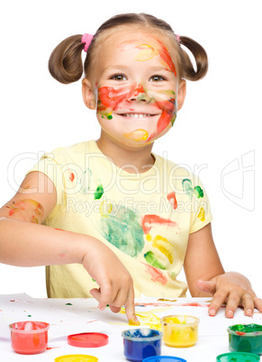 Portrait of a cute girl playing with paints