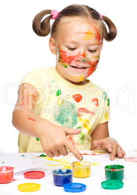 Portrait of a cute girl playing with paints