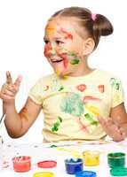 Portrait of a cute girl playing with paints