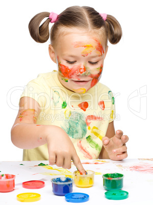 Portrait of a cute girl playing with paints