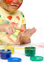 Portrait of a cute girl playing with paints