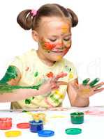 Portrait of a cute girl playing with paints