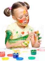 Portrait of a cute girl playing with paints