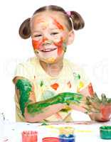 Portrait of a cute girl playing with paints