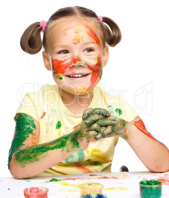 Portrait of a cute girl playing with paints