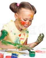 Portrait of a cute girl playing with paints