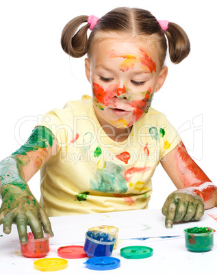 Portrait of a cute girl playing with paints