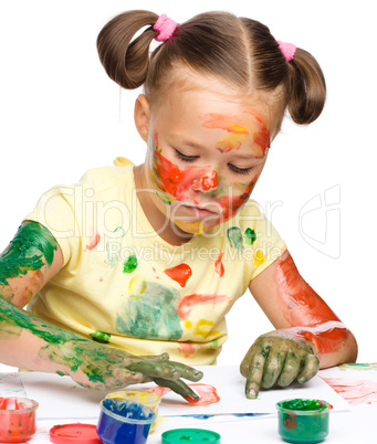 Portrait of a cute girl playing with paints