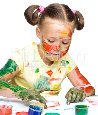 Portrait of a cute girl playing with paints