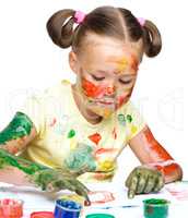 Portrait of a cute girl playing with paints