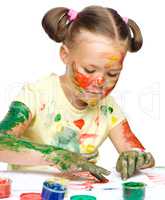 Portrait of a cute girl playing with paints