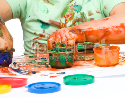 Little boy is playing with paints