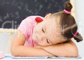 Little girl is sleeping on her writing-book