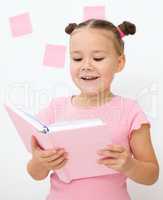 Little girl is reading a book