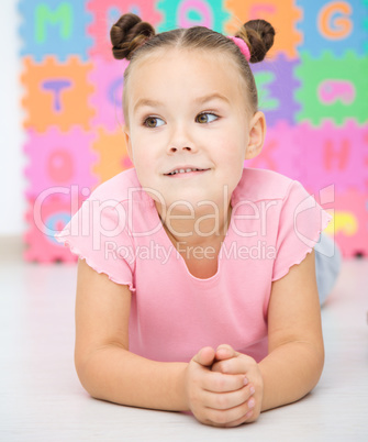 Little girl is laying on floor in preschool