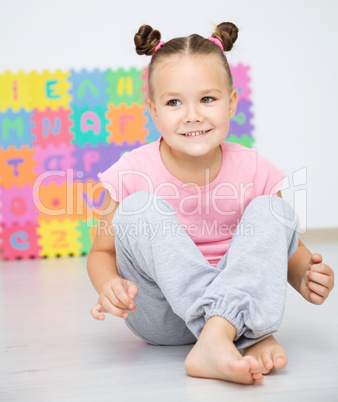 Little girl is sitting on floor in preschool