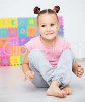 Little girl is sitting on floor in preschool