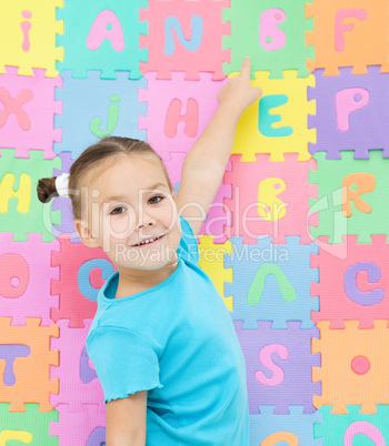 Little girl is pointing at letter B
