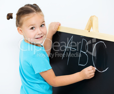 Little girl is showing letter E on the alphabet