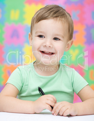 Little boy is writing on his copybook