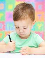 Little boy is writing on his copybook