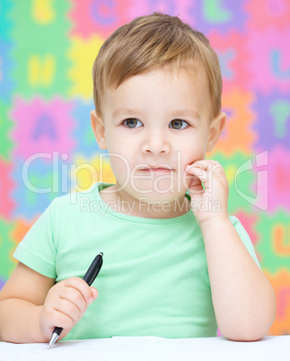 Little boy is writing on his copybook