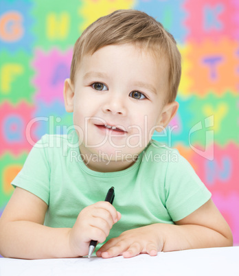 Little boy is writing on his copybook