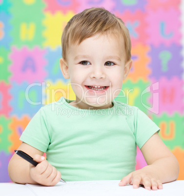 Little boy is writing on his copybook