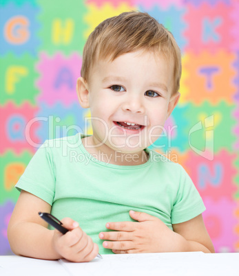 Little boy is writing on his copybook