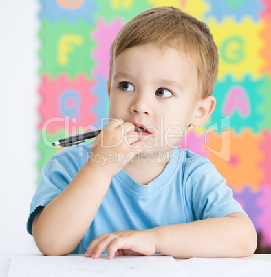 Little boy is writing on his copybook