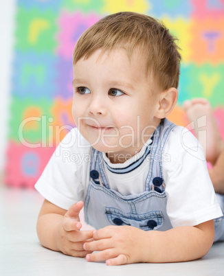 Little boy is laying on a floor