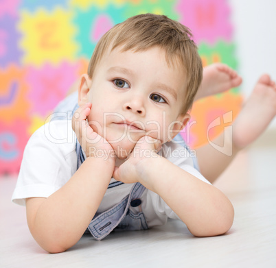 Little boy is laying on a floor