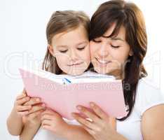 Mother is reading book with her daughter