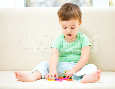 Boy is playing while sitting on couch