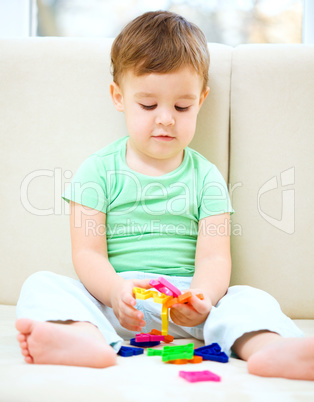 Boy is playing while sitting on couch