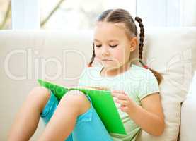 Little girl reads a book