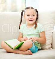 Little girl reads a book