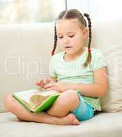 Little girl reads a book