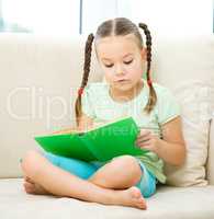 Little girl reads a book